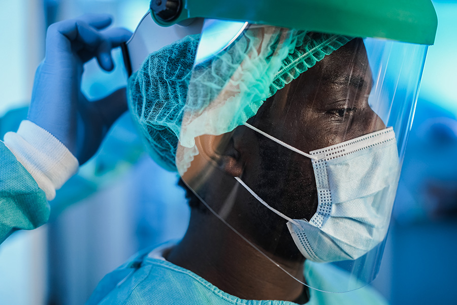 Medical doctors at work inside hospital during coronavirus outbreak - Focus on african man face